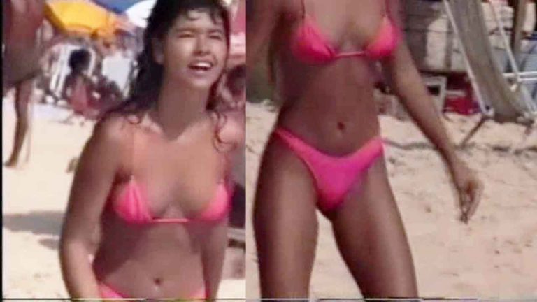Real Voyeur - Young girl on the beach in a pink bikini playing badminton