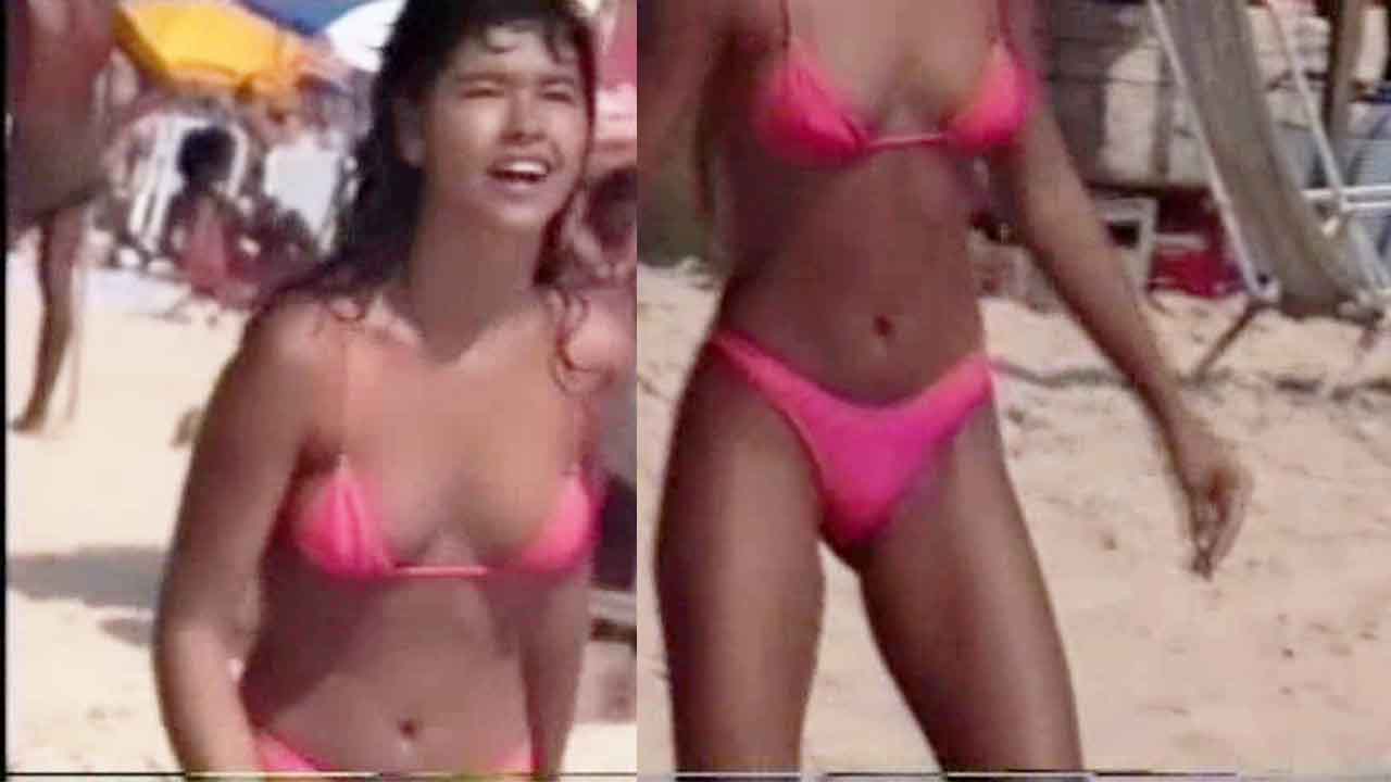 Real Voyeur - Young girl on the beach in a pink bikini playing badminton