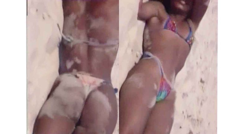 Voyeur brunette teen girl in a tight bikini rolling around in the beach sand